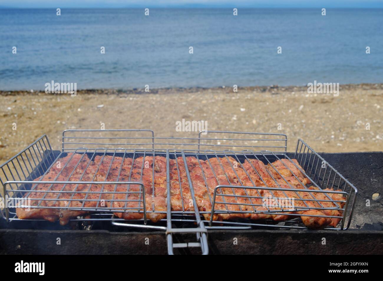 Barbecue sur la plage. La viande marinée est frite sur des coals chauds, trempés dans de la fumée parfumée. Mise au point sélective. Banque D'Images