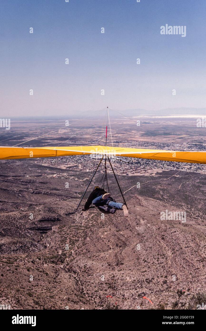 Un pilote de planeur suspendu part de la rampe de lancement de Horse Ridge à Dry Canyon, près d'Alamogordo, au Nouveau-Mexique. Au loin se trouve White Sands National Banque D'Images