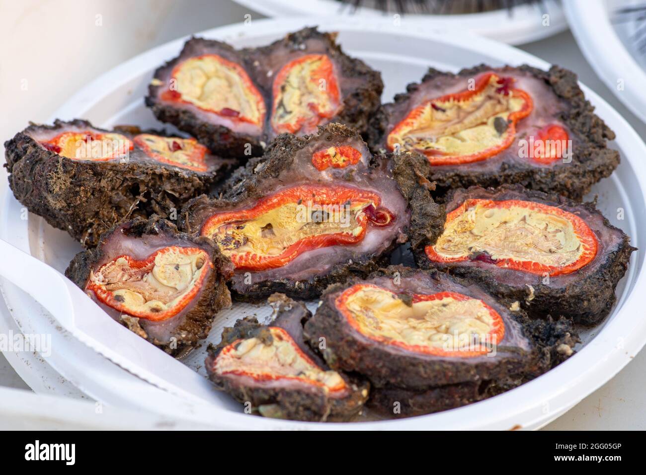 Ouvert à la main microcosmus sabatieri cru, Squirt de mer rainuré, truffe, citron ou mer d'oeuf, figue, éponge prête à manger dans une assiette dans un marché de poisson Banque D'Images