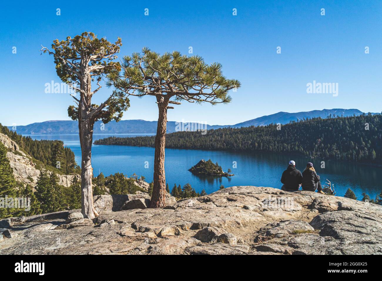 Deux personnes s'assoient sur un rocher surplombant Emerald Bay, Lake Tahoe, Californie Banque D'Images
