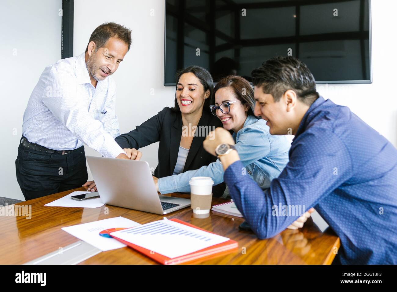 Les gens d'affaires mexicains dans le bureau moderne analysant des graphiques en utilisant l'ordinateur à Mexico Banque D'Images Les gens d'affaires mexicains dans le bureau moderne analysant des graphiques en utilisant l'ordinateur à Mexico Banque D'Images