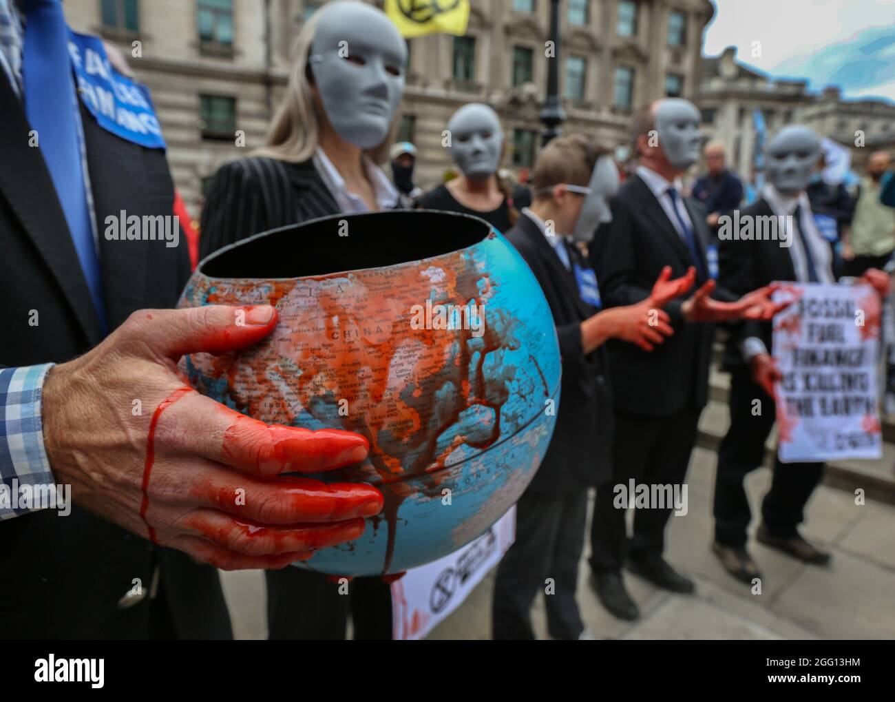 Londres, Royaume-Uni. 27 août 2021. Un rebelle habillé comme des financiers anonymes avec les mains couvertes de sang théâtral rejoint la manifestation dans le cadre de la rébellion impossible, pendant la marche. Ils croient que la ville de Londres a été construite sur l'argent du sang et exigent le changement au système colonial oppressif qui entraîne les crises du climat et du racisme. Ils exigent également que les politiques gouvernementales de lutte contre le changement climatique et écologique soient mises en œuvre et mettent immédiatement fin à tous les nouveaux investissements dans les combustibles fossiles. Crédit : SOPA Images Limited/Alamy Live News Banque D'Images