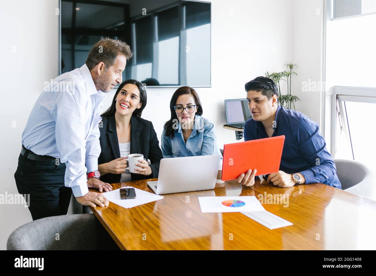 Groupe de gens d'affaires latins planifiant des projets utilisant l'ordinateur portable dans le bureau moderne au Mexique Banque D'Images Groupe de gens d'affaires latins planifiant des projets utilisant l'ordinateur portable dans le bureau moderne au Mexique Banque D'Images