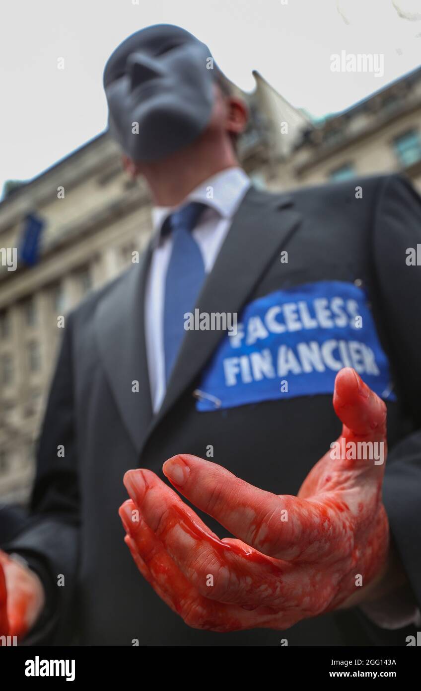 Londres, Royaume-Uni. 27 août 2021. Un rebelle habillé comme des financiers anonymes avec les mains couvertes de sang théâtral rejoint la manifestation dans le cadre de la rébellion impossible, pendant la marche. Ils croient que la ville de Londres a été construite sur l'argent du sang et exigent le changement au système colonial oppressif qui entraîne les crises du climat et du racisme. Ils exigent également que les politiques gouvernementales de lutte contre le changement climatique et écologique soient mises en œuvre et mettent immédiatement fin à tous les nouveaux investissements dans les combustibles fossiles. (Photo de Martin Pope/SOPA Images/Sipa USA) crédit: SIPA USA/Alay Live News Banque D'Images