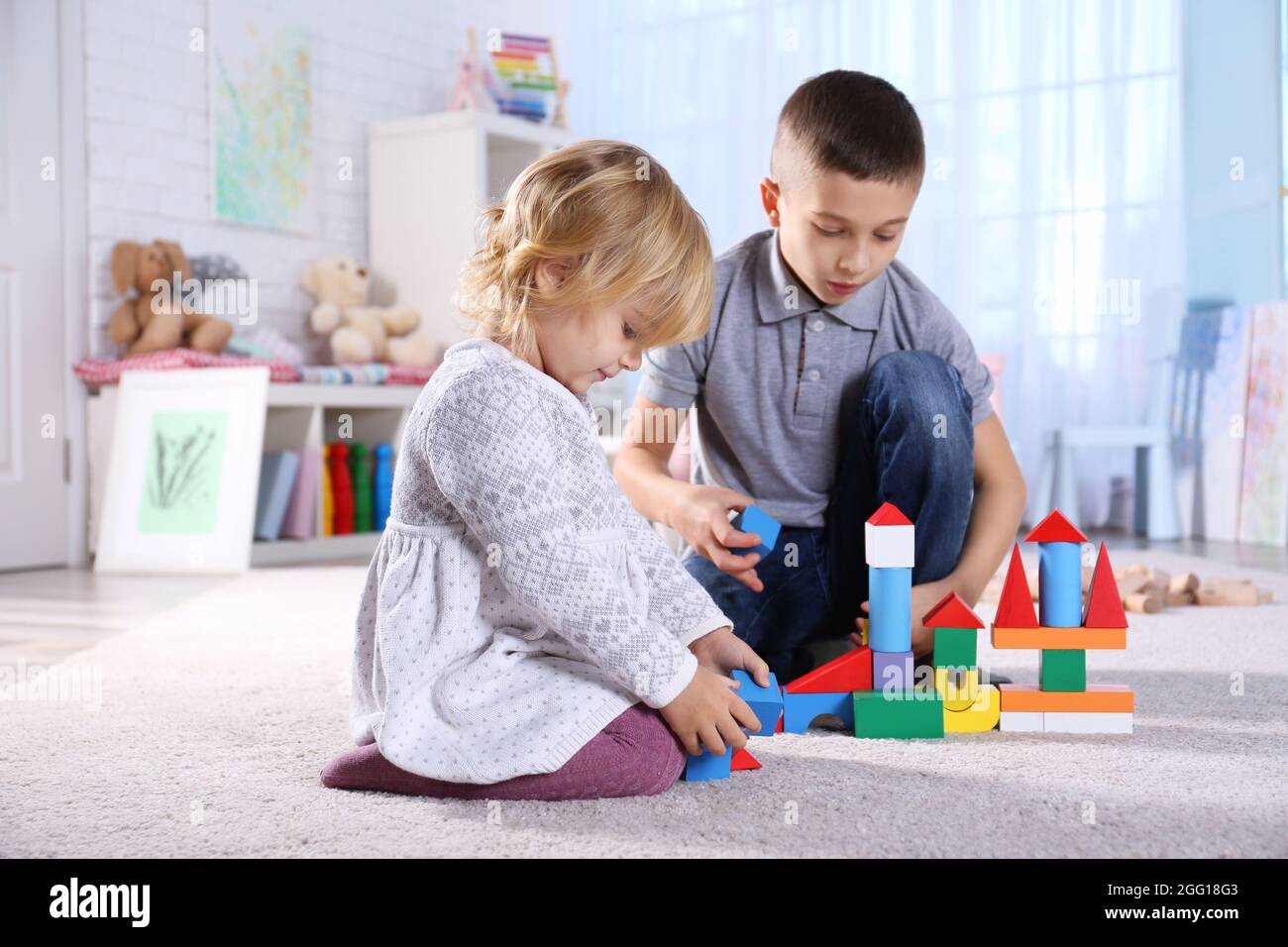Jolie petite soeur et son frère à jouer avec des blocs de jouets à la  maison Photo Stock - Alamy