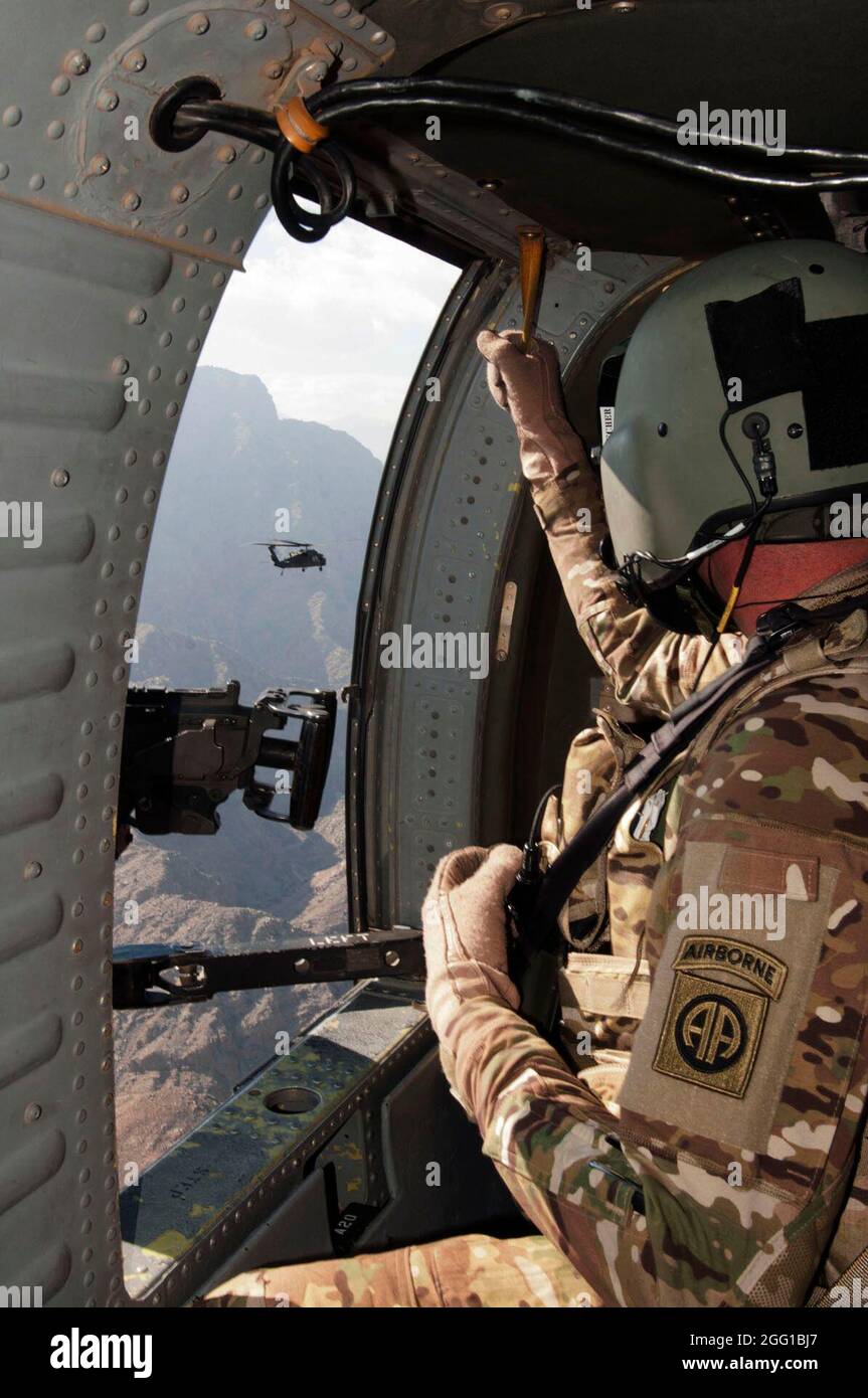 PROVINCE DE NANGARHAR, Afghanistan — Capt Tim Beecher, de St. Louis, Mo. Et avec la 82e Brigade de l'aviation de combat, la Force opérationnelle talon, porte le mitrailleur de calibre 50 à la porte d'un FAUCON noir UH 60, tandis qu'il et un autre Faucon noir survole la région de Tora Bora près de la frontière du Pakistan le 5 novembre (États-Unis Photo de l'armée par la SPC. Ken SCAR, 7e MPAD) Banque D'Images