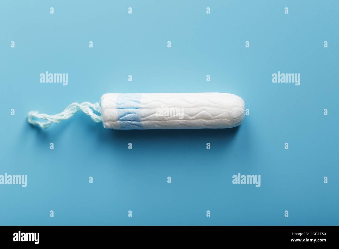 Tampon hygiénique sur fond bleu avec espace libre. Cycle menstruel