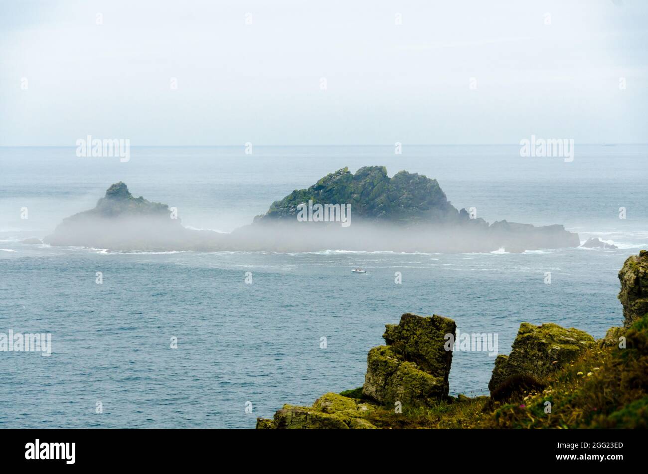 Les îles Brison ont été Shrouded in Mist - vue de Cape Cornwall avec UN bateau de pêche en face qui donne l'échelle - Angleterre Royaume-Uni Banque D'Images