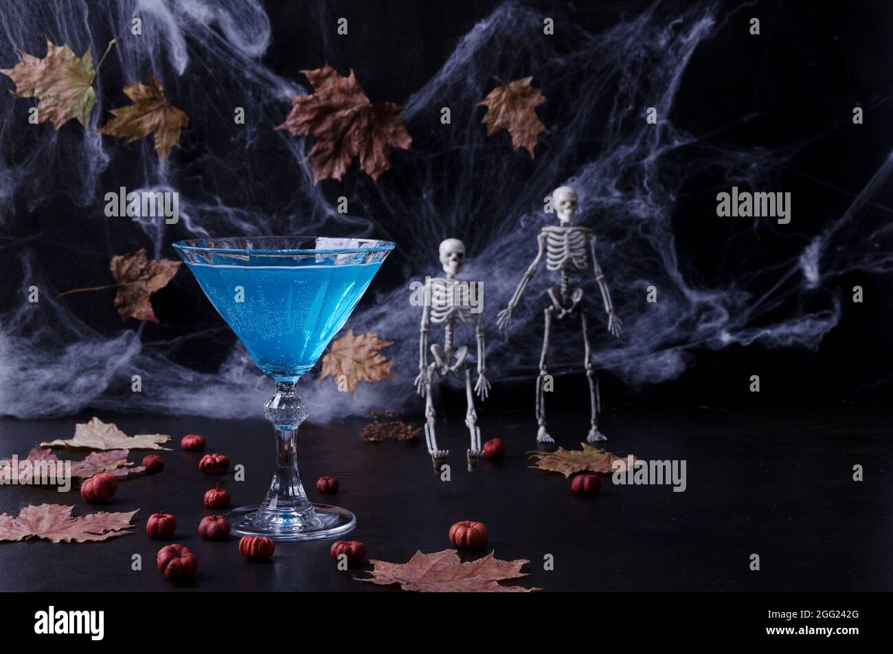 Cocktail d'Halloween. Boisson de fête. Fête d'Halloween. Citrouilles, toiles d'araignée, squelettes sur un fond sombre dans une clé sombre. Mise au point sélective Banque D'Images