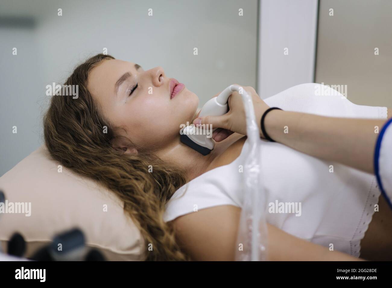 Médecin donnant au patient une échographie. Belle et jeune femme obtenant le contrôle de la glande thyroïde Banque D'Images