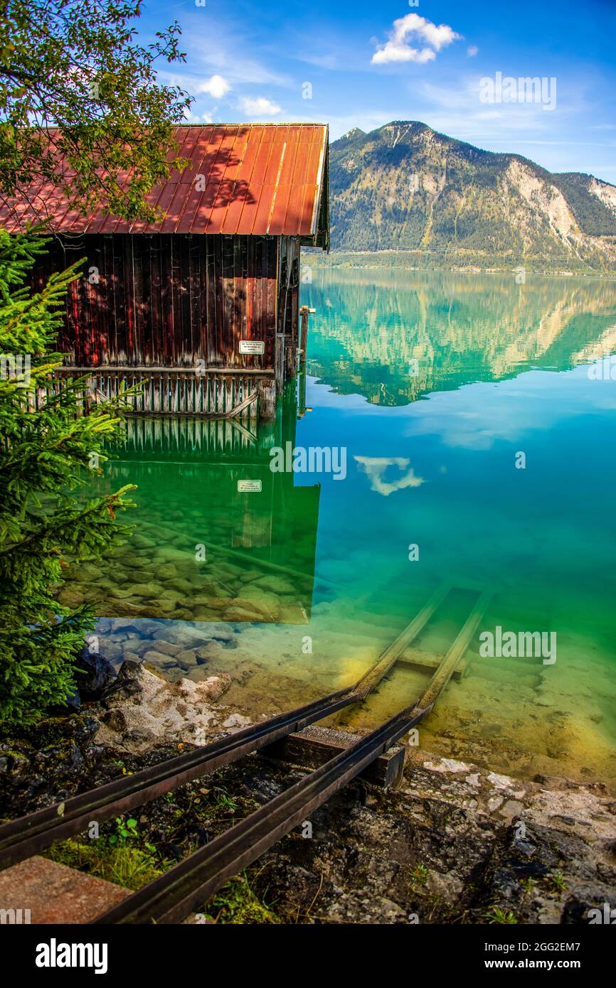 Paysage d'une maison de bateau, les hautes montagnes, l'eau du lac et le ciel bleu en Europe centrale Banque D'Images