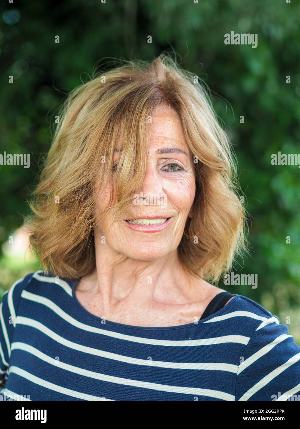 Femme italienne aînée en vêtements rayés appréciant les vibes dans un parc  Photo Stock - Alamy