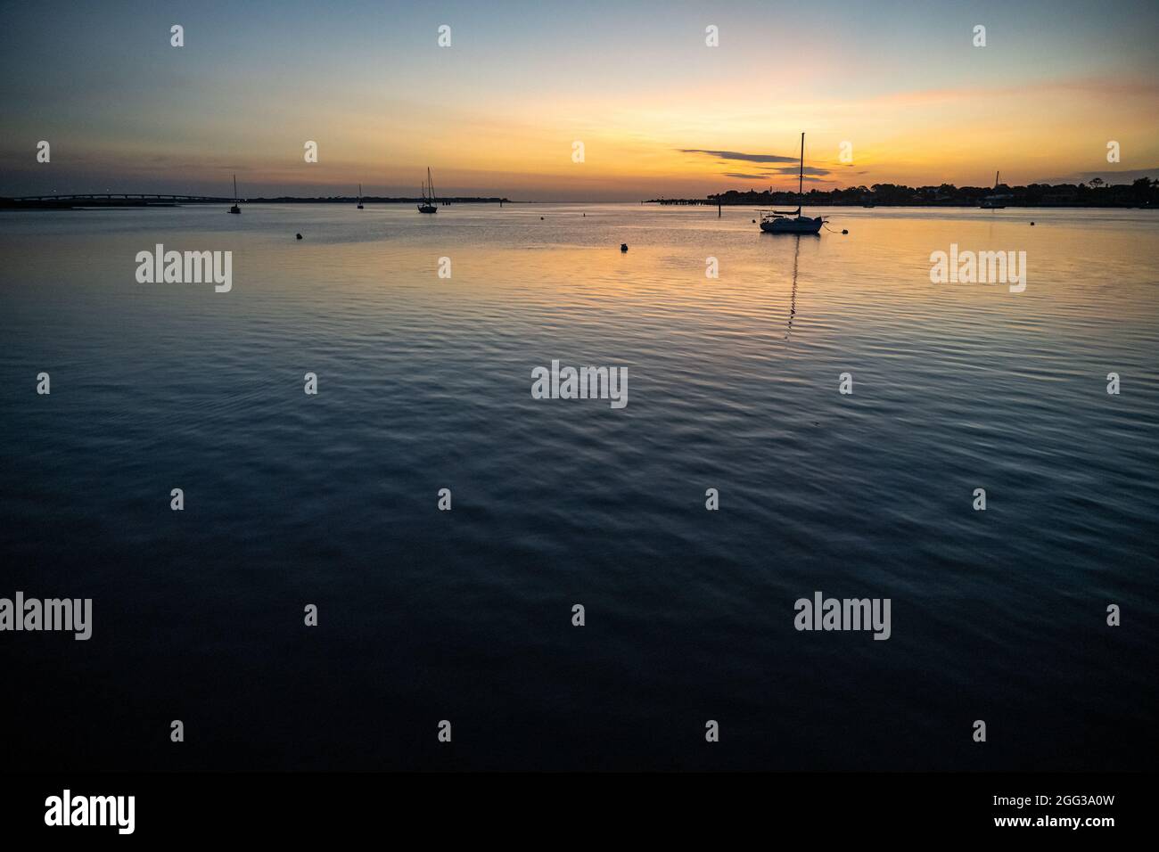 Des voiliers qui haringuent dans la baie de Matanzas à l'aube à Saint Augustine, en Floride, avec Vilano Beach, Matanzas Inlet, et Anastasia Island vus au loin. Banque D'Images