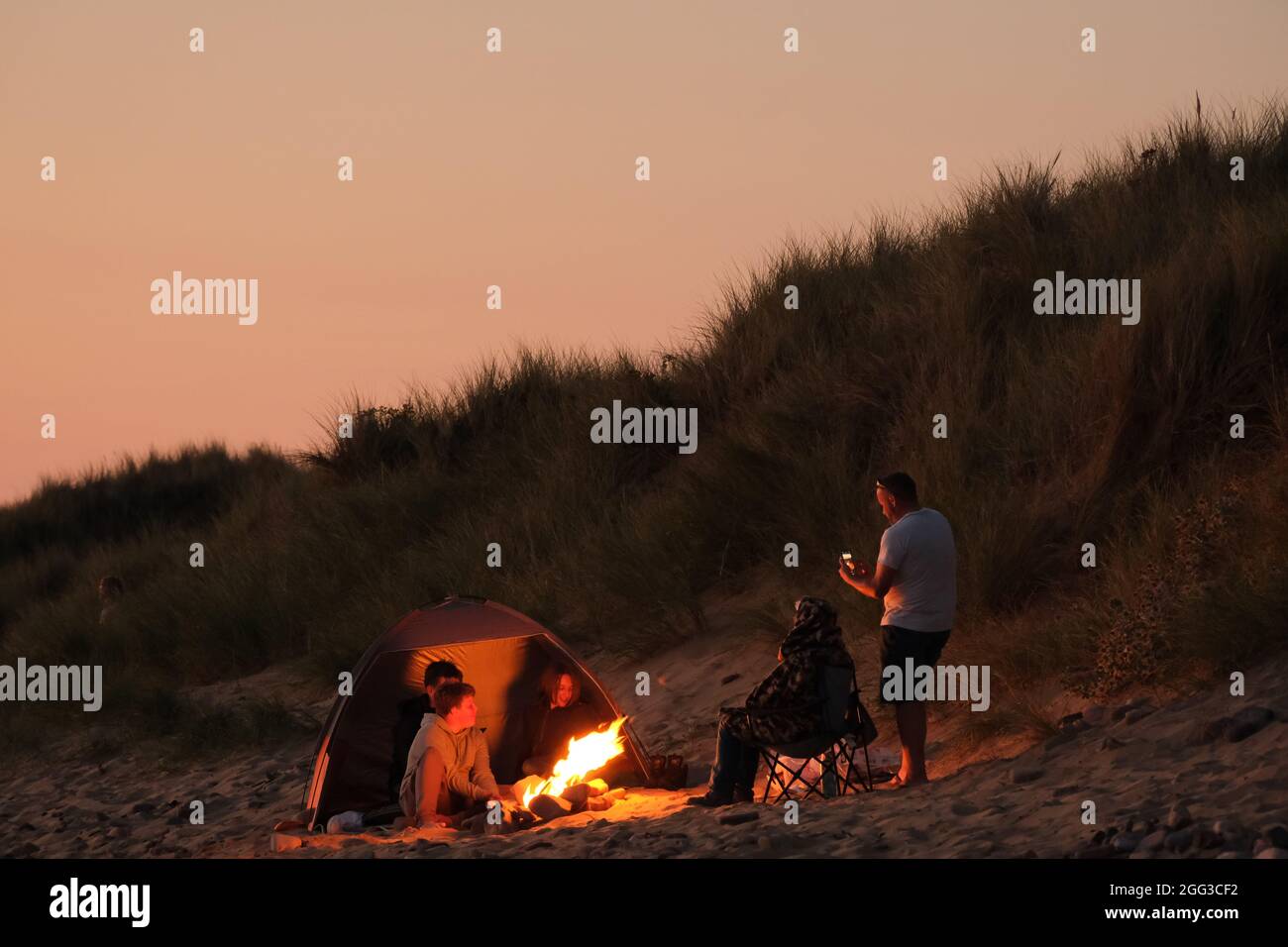Feux de camp d'été sur la plage de Llangennith, péninsule de Gower, près de Swansea, Royaume-Uni. Remarque : les images peuvent présenter une légère douceur et un certain bruit de signal, tel qu'il est pris avec des paramètres ISO très élevés. Ne convient pas à une reproduction plus large. Banque D'Images