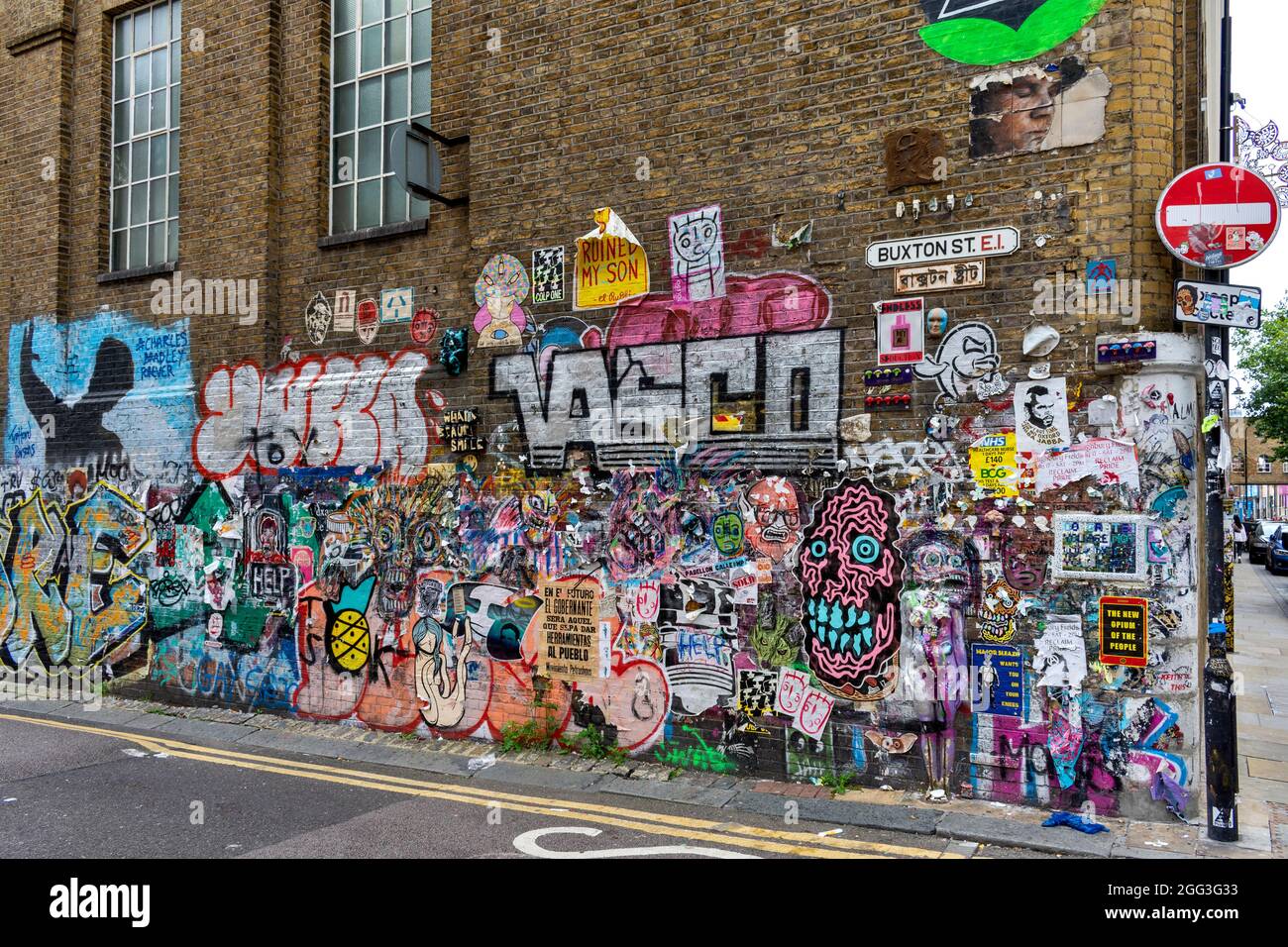 QUARTIER ARTISTIQUE ET CULTUREL DE LONDRES AUTOUR DE LA RUELLE DE BRIQUES AVEC DES MOTIFS ET DES SLOGANS CRÉATIFS DANS BUXTON STREET Banque D'Images