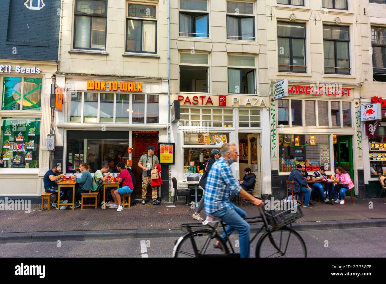 Amsterdam, Hollande, scènes de rue, rangée de magasins, touristes partageant des repas sur la terrasse des restaurants rapides, vélos, centre-ville d'amsterdam Banque D'Images