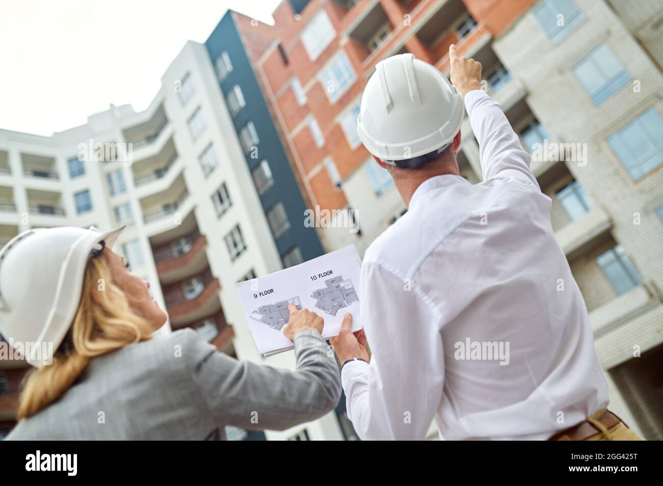 Deux collègues caucasiens inspectant ensemble un objet de construction Banque D'Images