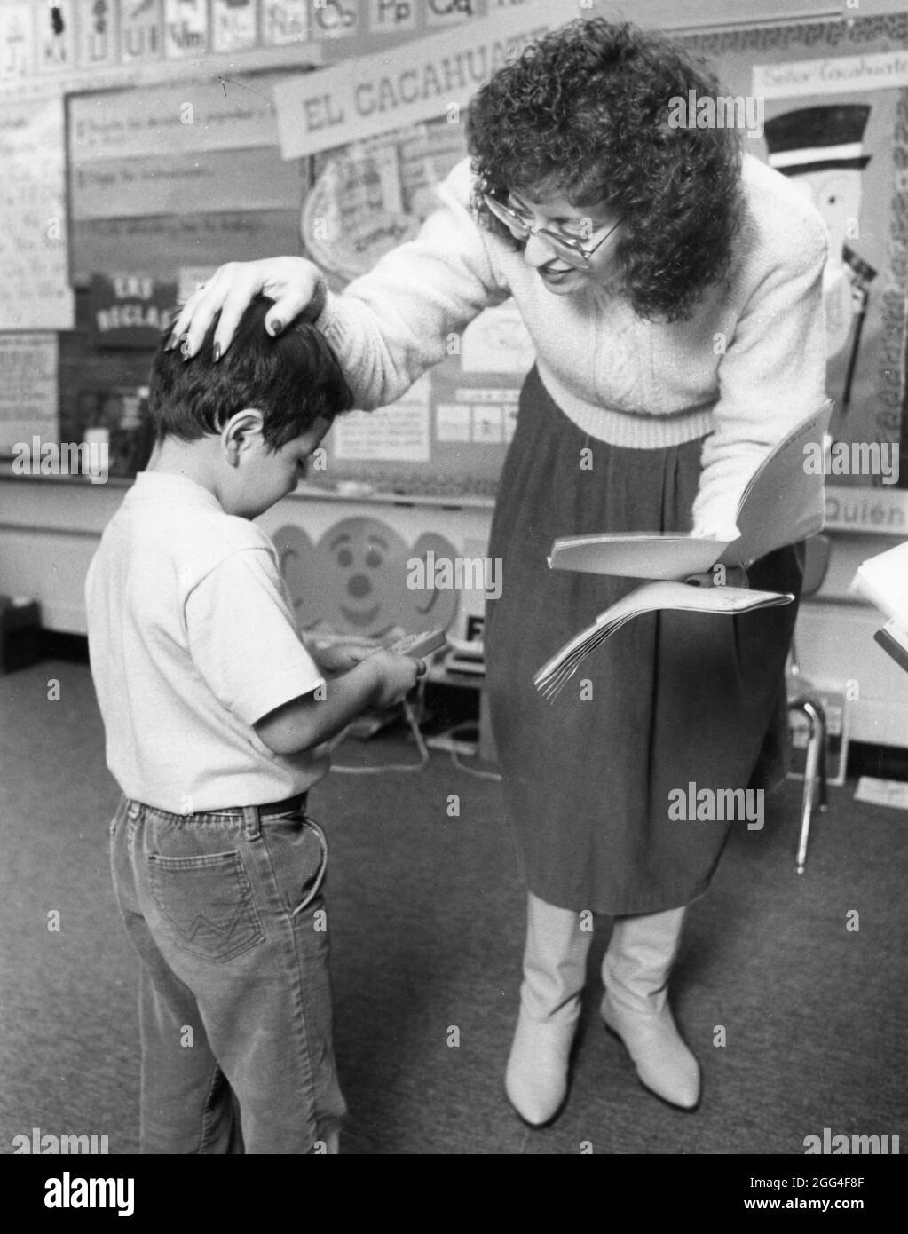 Austin Texas USA, vers 1991:l'enseignant d'enseignement bilingue hispanique penche vers le bas pour parler à l'élève de maternelle à l'école élémentaire de Sanchez. EV3-0326 ©Bob Daemmrich Banque D'Images Austin Texas USA, vers 1991:l'enseignant d'enseignement bilingue hispanique penche vers le bas pour parler à l'élève de maternelle à l'école élémentaire de Sanchez. EV3-0326 ©Bob Daemmrich Banque D'Images