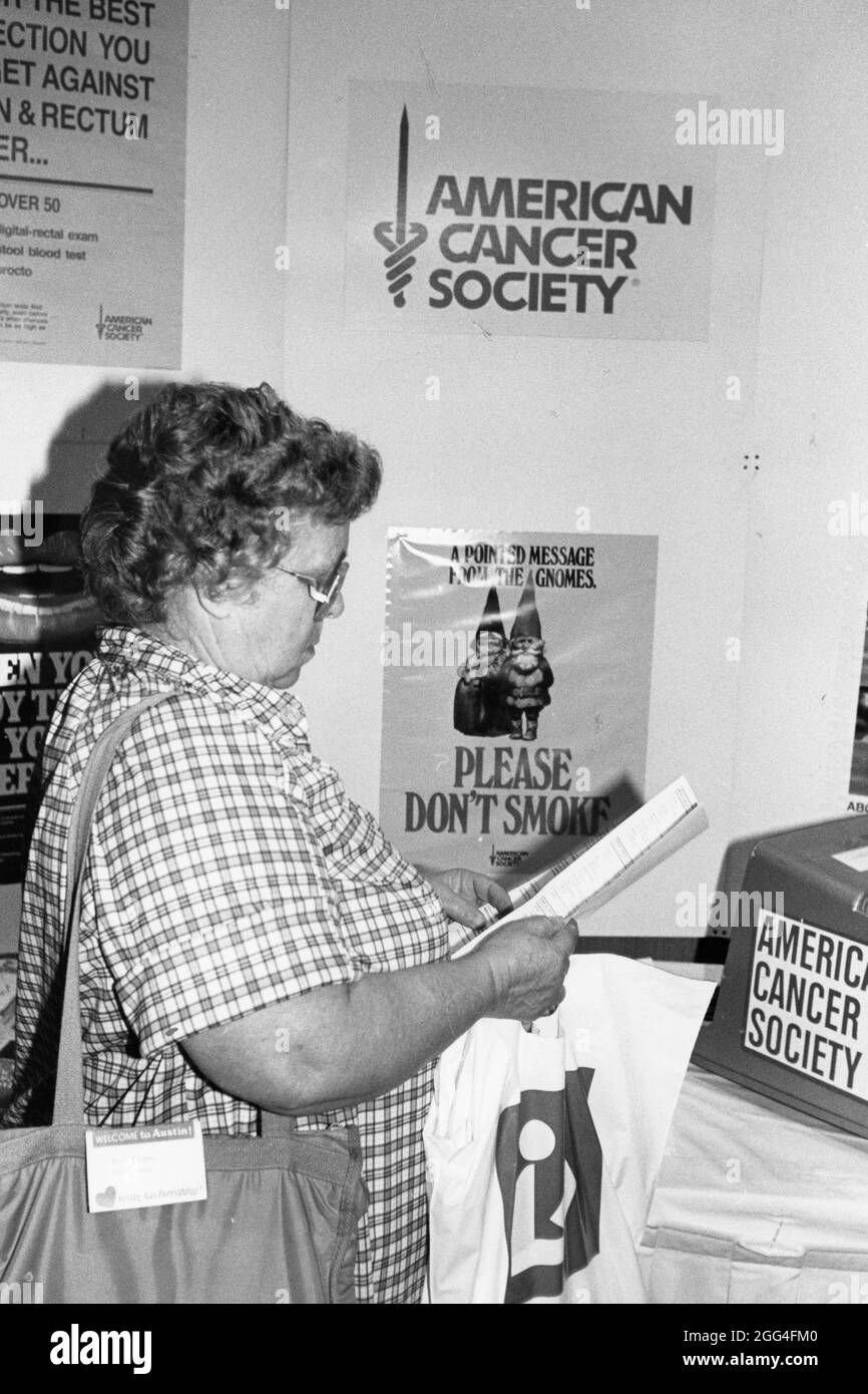 Austin Texas USA, vers 1990: Une femme a participé à une conférence sur le vieillissement pour regarder les matériaux au stand de l'American cancer Society. ©Bob Daemmrich Banque D'Images