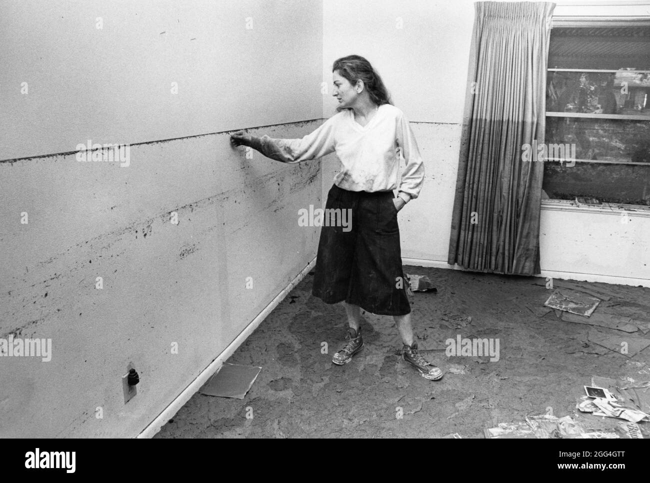Austin Texas USA, 1982 : pendant le nettoyage des inondations, Woman montre comment les eaux de crue ont augmenté à l'intérieur de sa maison. ©Bob Daemmrich Banque D'Images