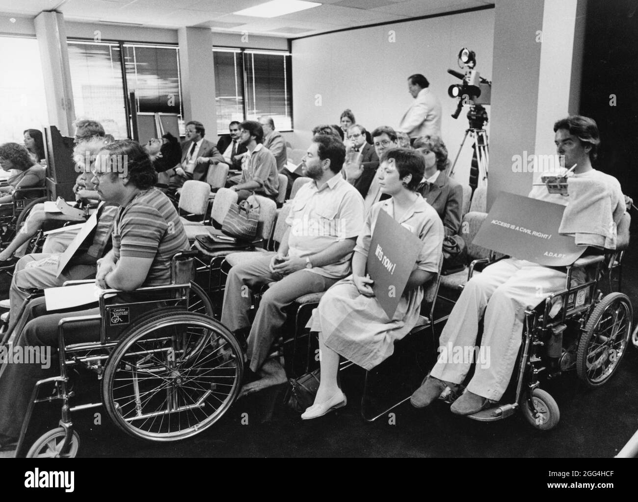 1987: Les membres de la communauté handicapée viennent en force à la réunion du conseil des transports de la ville pour préconiser un service d'autobus plus accessible. Banque D'Images