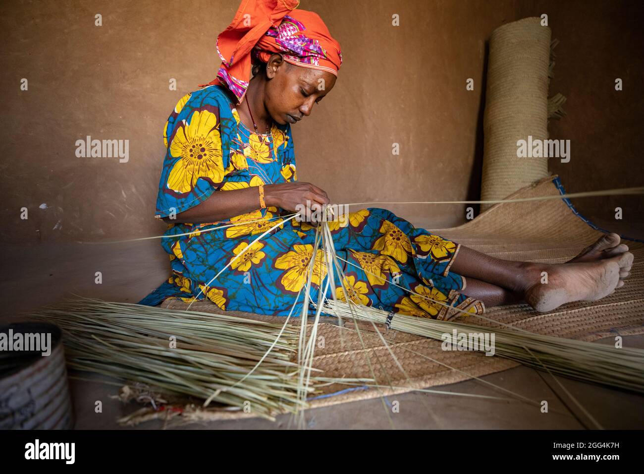 Une femme Fulani déménage à la main des matts et des fans de palmier séché pour la subsistance de sa famille dans la région de Ségou, Mali, Afrique de l'Ouest. Banque D'Images