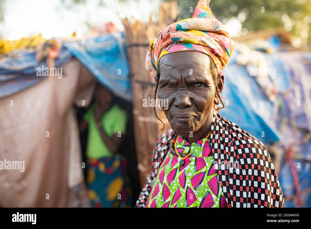 Le camp de Senou se trouve à la limite sud de Bamako, la capitale du Mali. C'est l'un des huit camps informels autour de la ville et, en soi, il abrite 223 familles et un peu plus de 1 000 personnes déplacées. Les familles qui vivent ici ont fui la violence et l'insurrection dans le nord et le centre du pays. Parce que la plupart d'entre eux n'ont pas de moyens de revenu ou de source régulière de nourriture, la faim est un défi quotidien et la malnutrition de sa population reste endémique. Ici, Fatima Barry se tient à l’extérieur du refuge de fortune de sa famille. Banque D'Images