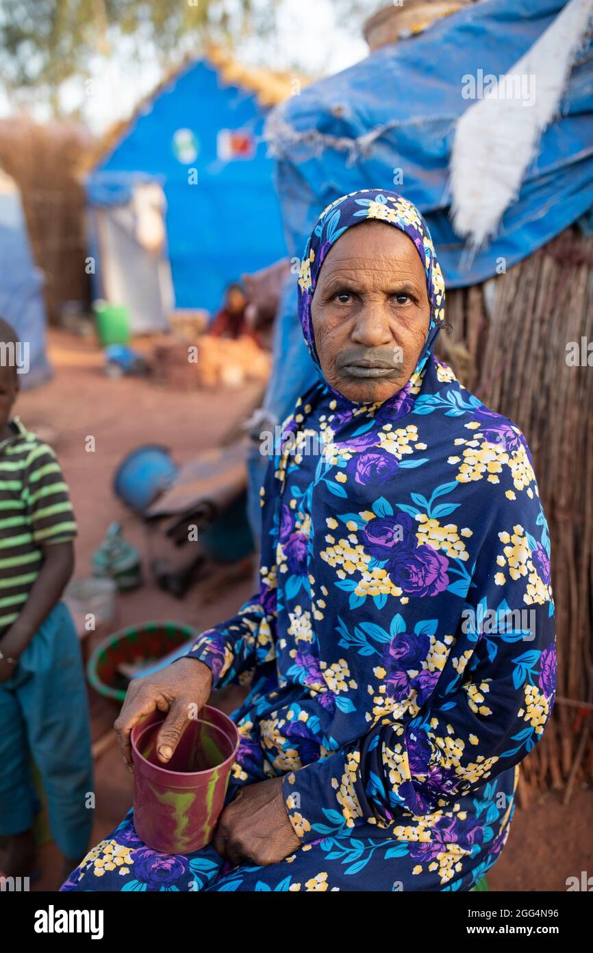Le camp de Senou se trouve à la limite sud de Bamako, la capitale du Mali. C'est l'un des huit camps informels autour de la ville et, en soi, il abrite 223 familles et un peu plus de 1 000 personnes déplacées. Les familles qui vivent ici ont fui la violence et l'insurrection dans le nord et le centre du pays. Parce que la plupart d'entre eux n'ont pas de moyens de revenu ou de source régulière de nourriture, la faim est un défi quotidien et la malnutrition de sa population reste endémique. Ici, Soumai Tali se trouve à l’extérieur du refuge de fortune de sa famille. Banque D'Images
