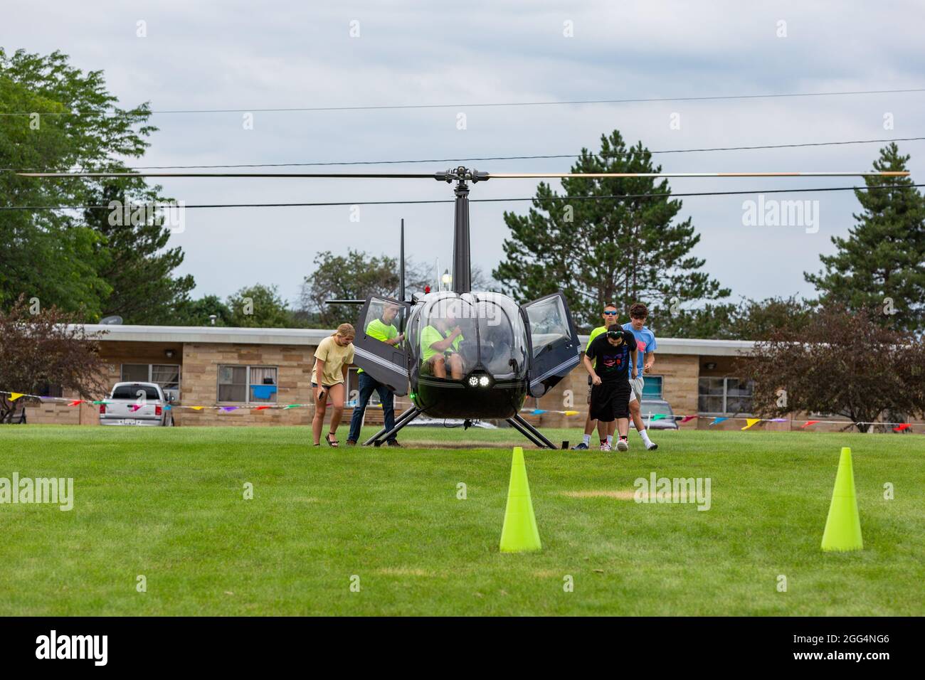 Les passagers quittent un hélicoptère Robinson R44 Raven II après avoir atterri en Angola, Indiana, États-Unis. Banque D'Images