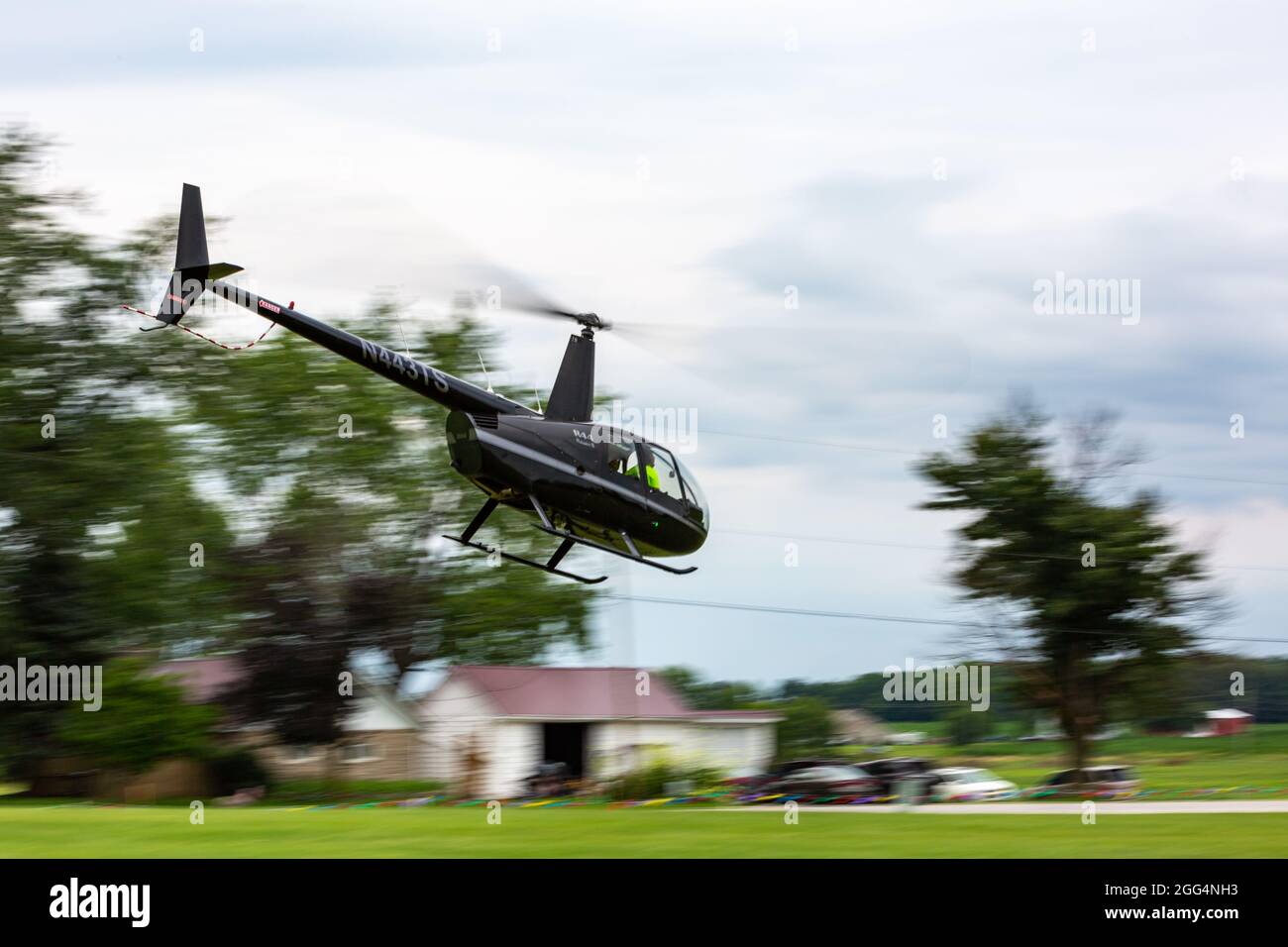 Un hélicoptère Robinson R44 Raven II vole près du sol en Angola, dans l'Indiana, aux États-Unis. Banque D'Images