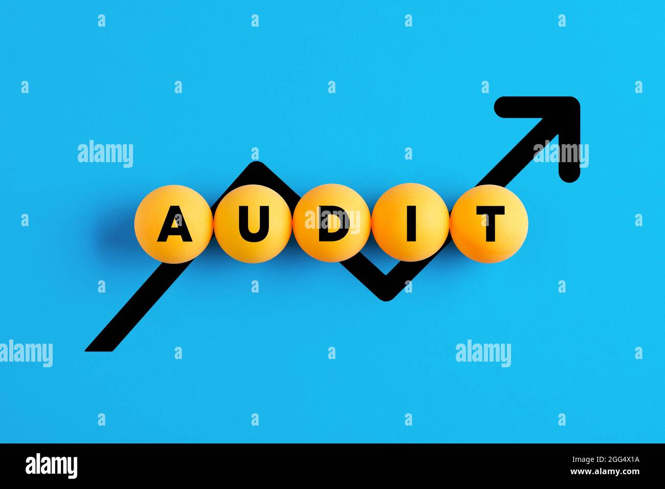 Le terme audit écrit sur des boules jaunes avec un graphique de ligne croissant sur fond bleu. Audit financier. Banque D'Images