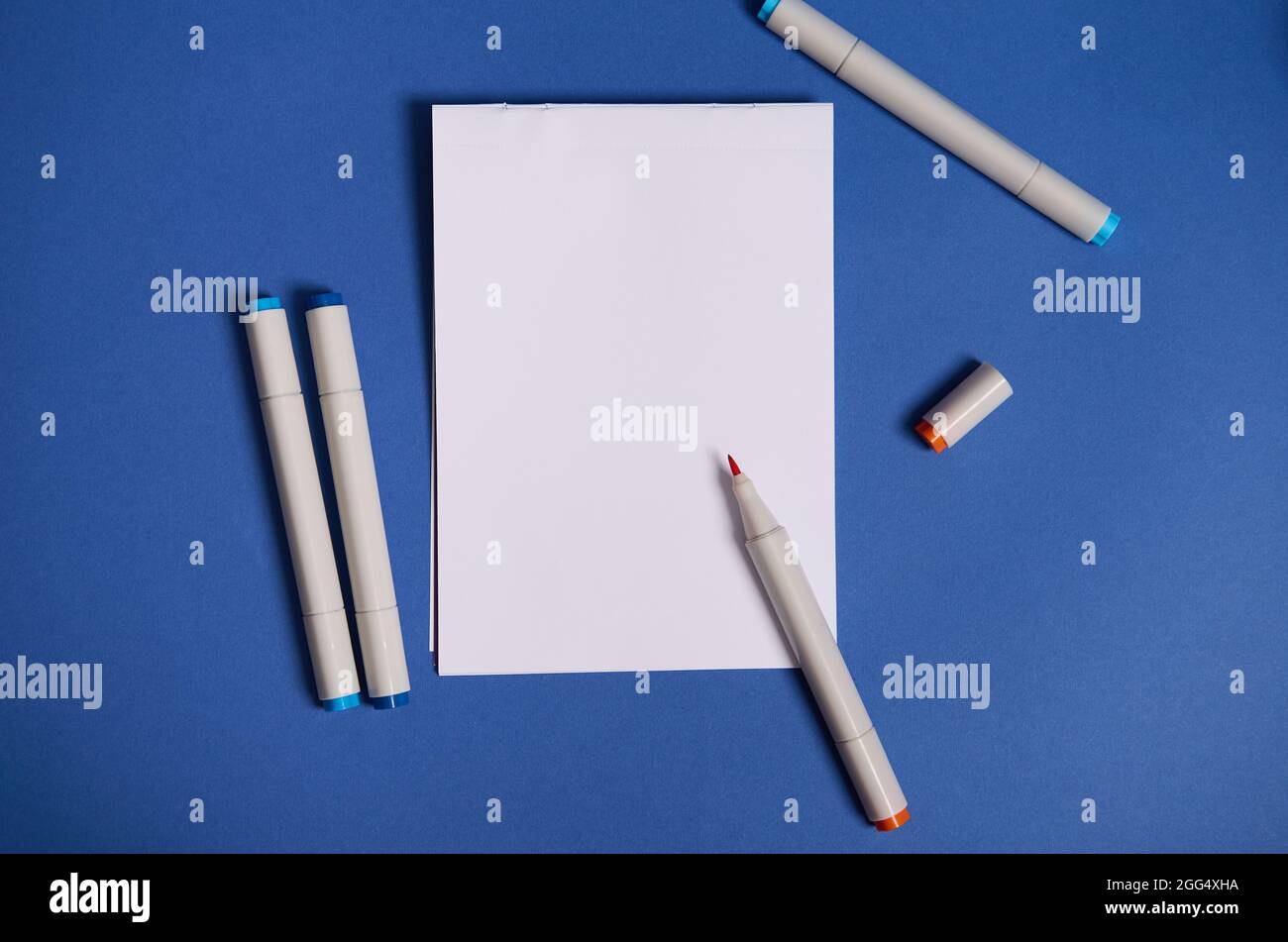 Composition de pose dichromatique à plat avec marqueurs d'aquarelle ou  stylos-feutres avec feuille de papier vierge blanche vide avec espace de  copie, isolée sur fond bleu Photo Stock - Alamy