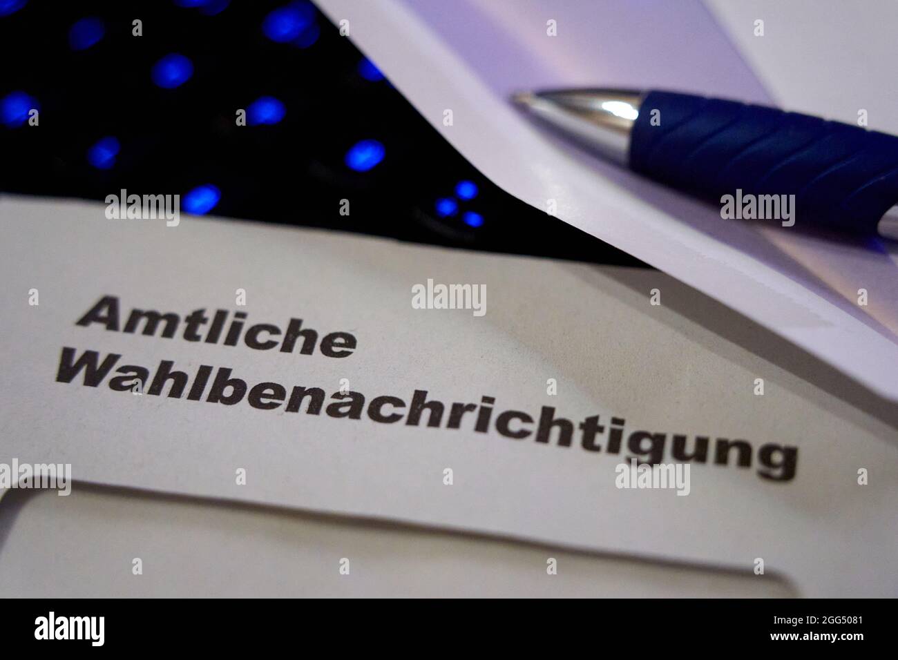Lettres noires sur enveloppe blanche disant: Notification officielle des élections (allemand: Amtliche Wahlbenachrichtigung). Le clavier noir s'allume en bleu dans le fond de l'écran Banque D'Images