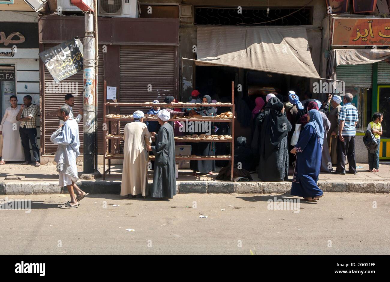 Les gens se rassemblent à l'entrée d'une boulangerie dans une rue d'Edfu, dans le centre de l'Égypte. Banque D'Images