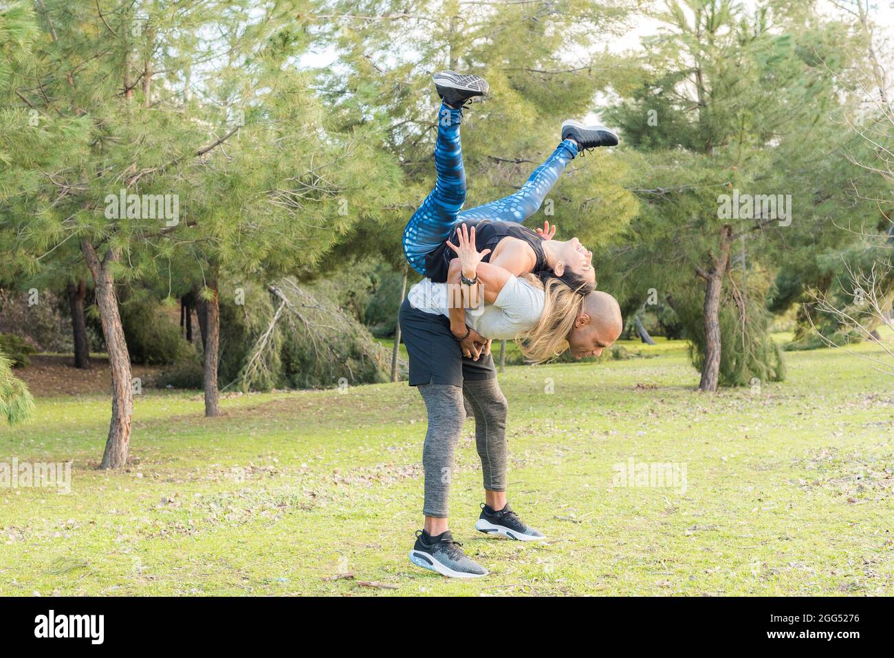 Un couple de remise en forme fait un exercice de levage dos à dos dans le parc Banque D'Images