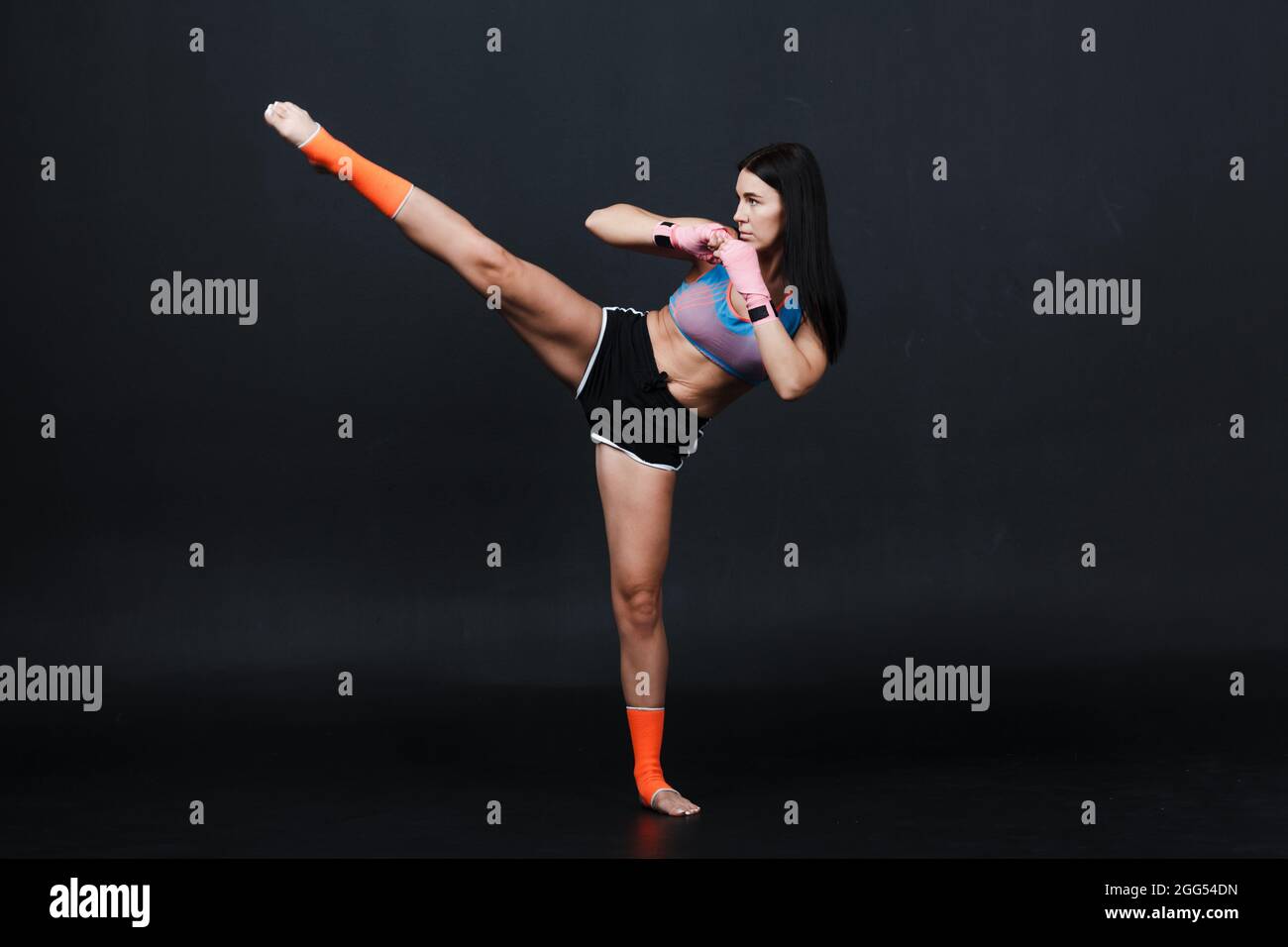 Sportsman muay thai boxeur femme posant dans le studio d'entraînement Banque D'Images