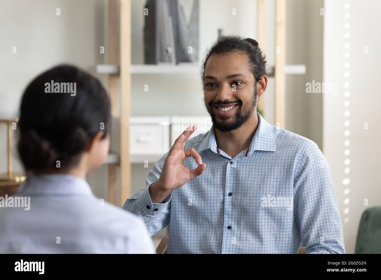 Souriant jeune africain américain pratiquant la langue des signes avec le médecin. Banque D'Images