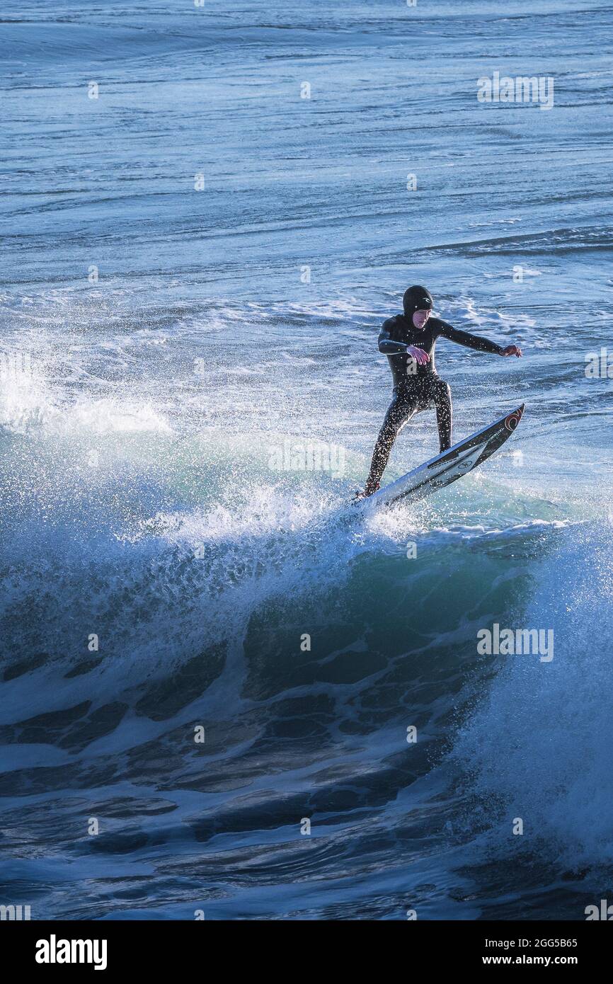 Un surfeur qui s'aprise d'une vague à Fistral, à Newquay, en Cornouailles. Banque D'Images