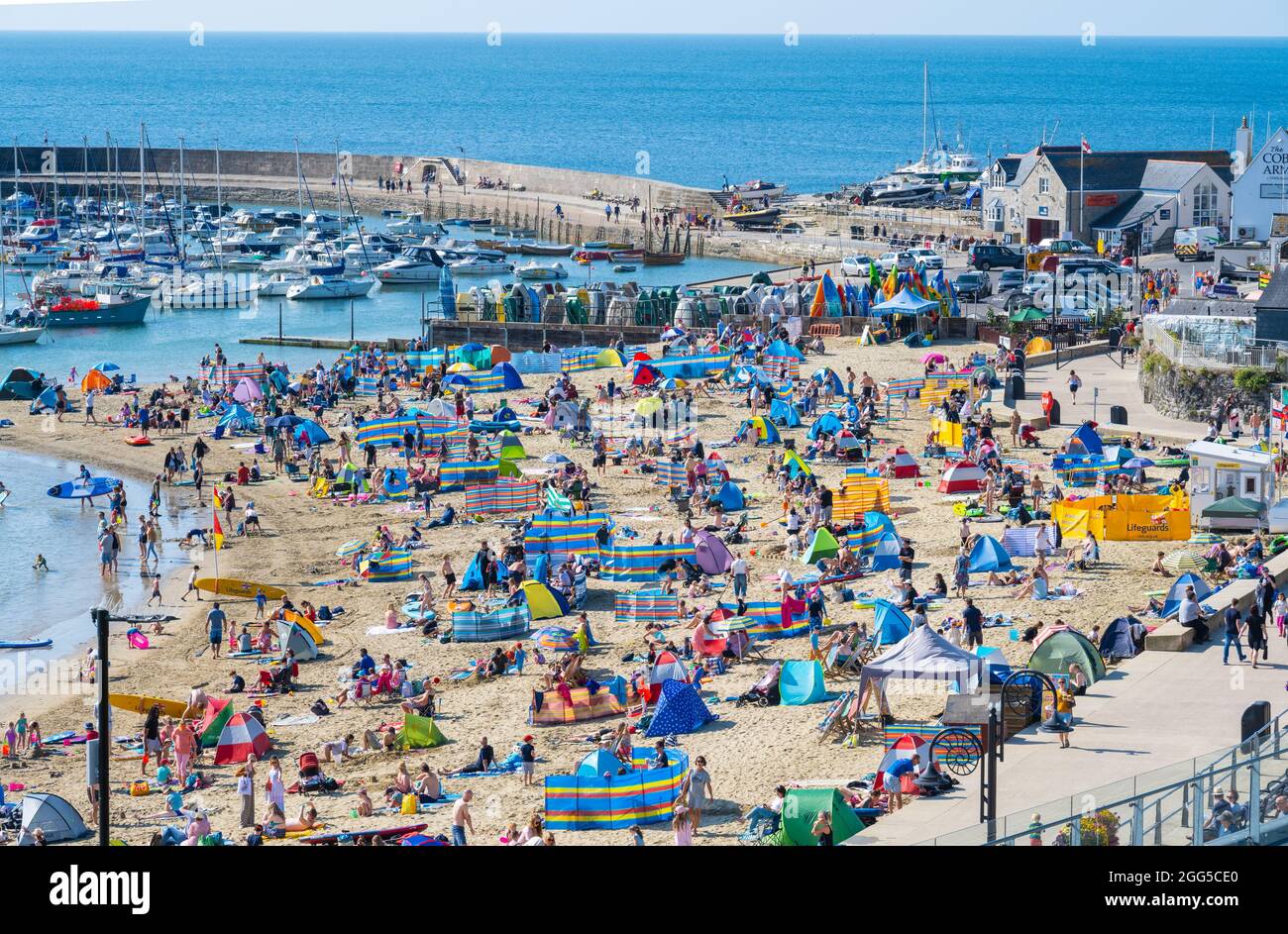 Lyme Regis, Dorset, Royaume-Uni. 29 août 2021. Météo au Royaume-Uni: Vacanciers et familles affluent à la plage populaire de la station balnéaire de Lyme Regis pour vous imprégner du soleil brûlant et du ciel bleu clair pendant le week-end de vacances en banque. Avec le beau temps qui se poursuivra jusqu'à Bank Holiday Monday, les plages et les stations balnéaires le long de la côte sud devraient être encore plus remplies que d'habitude, car plus de gens aiment les promenades au Royaume-Uni cet été. Le crédit: Celia McMahon/Alamy Live News Banque D'Images