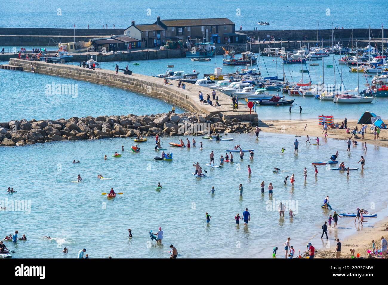 Lyme Regis, Dorset, Royaume-Uni. 29 août 2021. Météo au Royaume-Uni: Vacanciers et familles affluent à la plage populaire de la station balnéaire de Lyme Regis pour vous imprégner du soleil brûlant et du ciel bleu clair pendant le week-end de vacances en banque. Avec le beau temps qui se poursuivra jusqu'à Bank Holiday Monday, les plages et les stations balnéaires le long de la côte sud devraient être encore plus remplies que d'habitude, car plus de gens aiment les promenades au Royaume-Uni cet été. Le crédit: Celia McMahon/Alamy Live News Banque D'Images