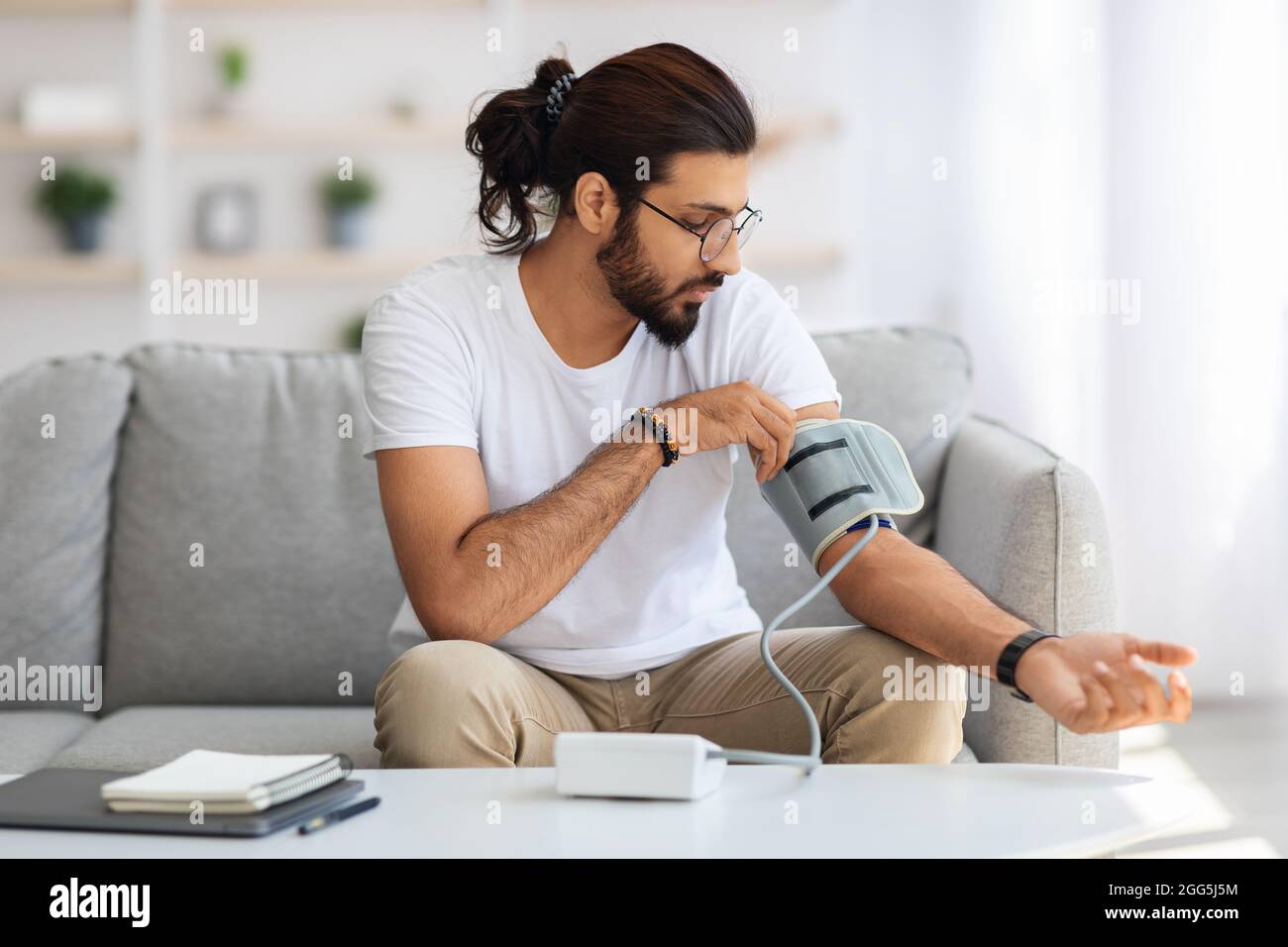 Homme du Moyen-Orient vérifiant la tension artérielle à la maison Banque D'Images
