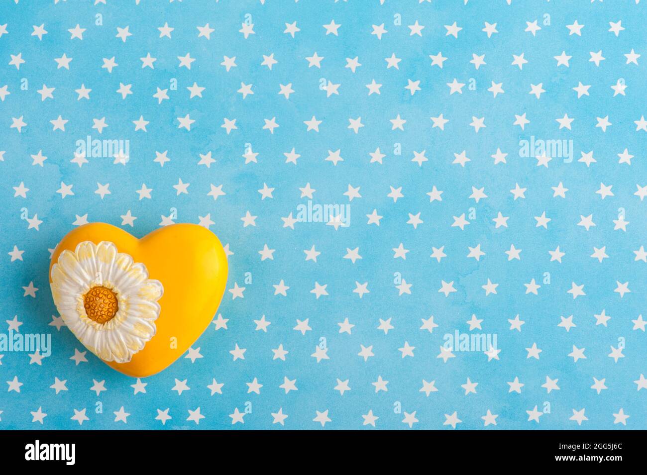 Fond bleu blanc étoiles avec coeur jaune. Invitation à une fête de douche de bébé, vue du dessus Banque D'Images