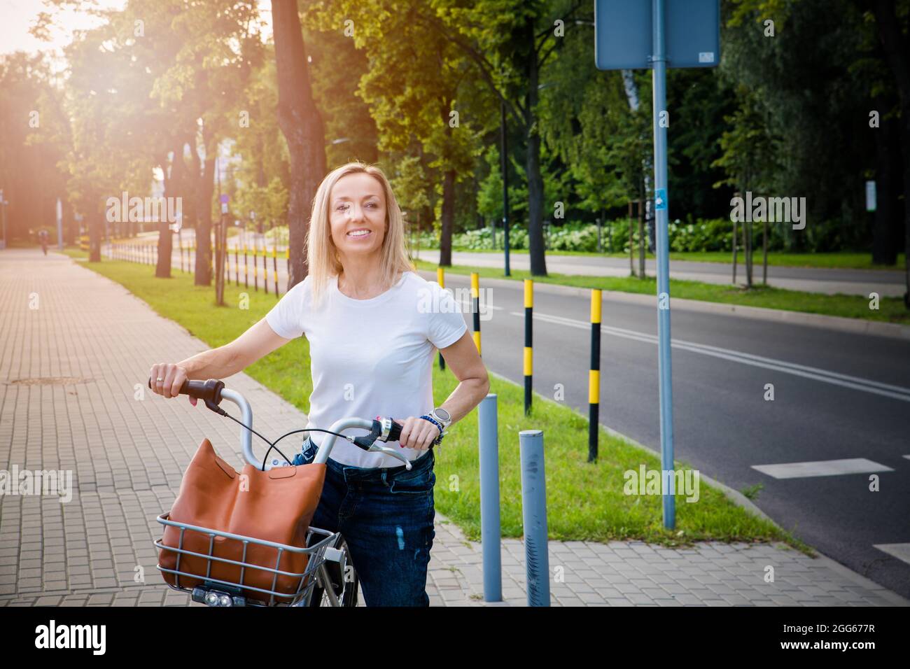 Belle et joyeuse femme profiter de la promenade à vélo dans une ville ensoleillée de loisirs en plein air dans la ville. Banque D'Images