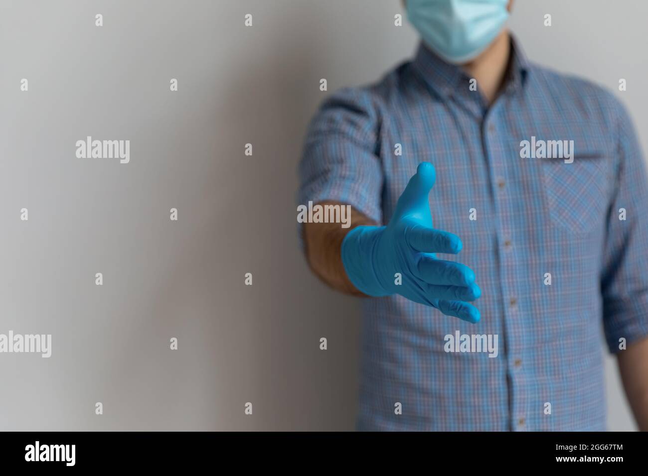 Homme portant un masque médical et des gants en latex de caoutchouc bleu Banque D'Images