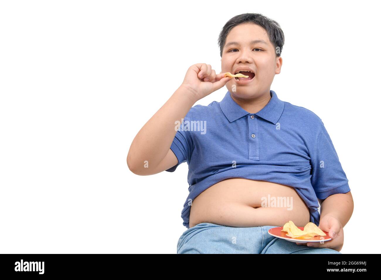 Obésité fat boy eating potato chips isolé sur fond blanc, ou d'aliments malsains junk food concept Banque D'Images