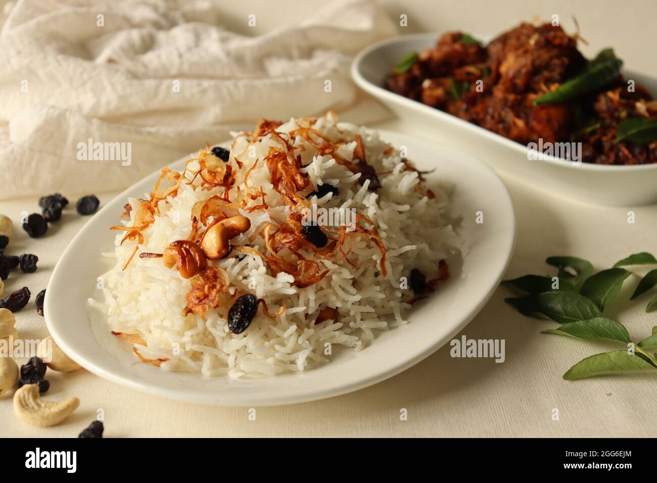 Plat de riz à base de riz Basmati, de ghee et d'épices et garni d'oignons frits servis avec un rôti de poulet épicé de style Kerala. Un repas populaire combinati Banque D'Images