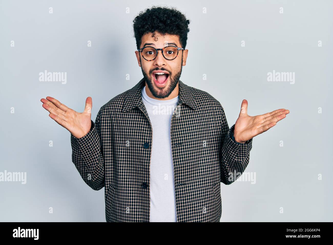 Jeune homme arabe avec une barbe portant des lunettes célébrant fou et  stupéfié pour le succès avec les bras levés et les yeux ouverts criant  excités. Concept gagnant Photo Stock - Alamy