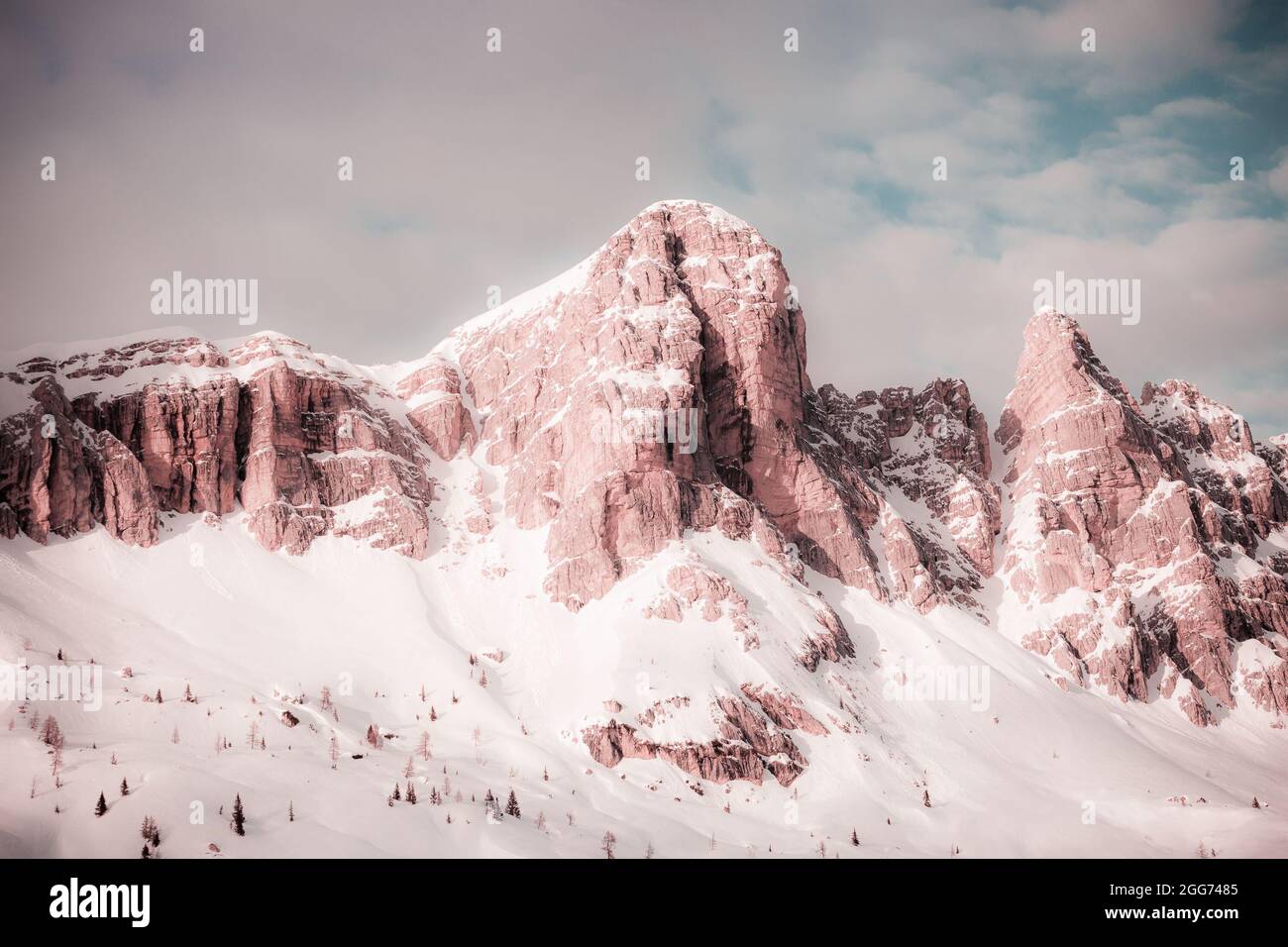Effet de couleur rose fantaisie des parois sud enneigées des pics de dolomite de Rocchette Banque D'Images
