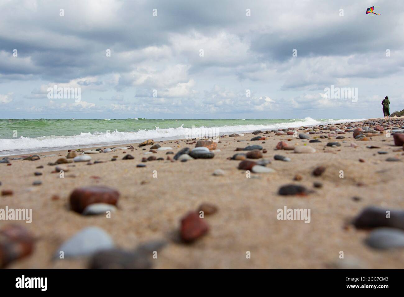 Petits cailloux dispersés sur la plage sable gros plan.faible profondeur de champ.attention sélective sur les pierres de premier plan.UN fond flou de sto multicolore Banque D'Images