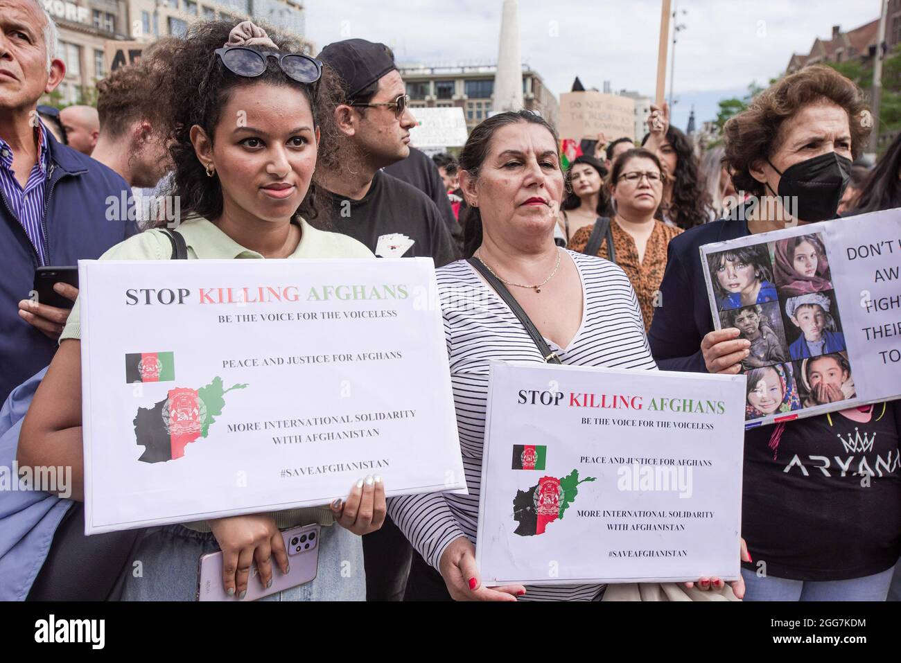 Les manifestants tiennent des écriteaux exprimant leur opinion pendant la manifestation. Plus d'un millier de personnes se sont rassemblées pour manifester sur la place du Dam, pour montrer leur soutien à la récente détresse des Afghans, maintenant à la merci des Taliban. Le gouvernement néerlandais a désigné l'Afghanistan comme un pays dangereux, ce qui signifie que les réfugiés ont droit à la protection et à l'asile politique. La manifestation d'aujourd'hui a été organisée par 'Azadi', un mouvement de jeunes Afghans néerlandais, qui fait désormais partie d'un mouvement international 'Top Killing Afghans Now. Le mouvement a organisé 15 démonstrations à travers l'Europe et la citie américaine Banque D'Images